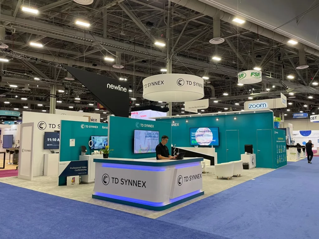 Custom trade show exhibit rental with a large LED video wall and modern furniture on the floor of a convention center in Orlando.