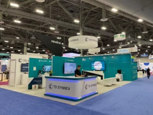 Custom trade show exhibit rental with a large LED video wall and modern furniture on the floor of a convention center in Orlando.