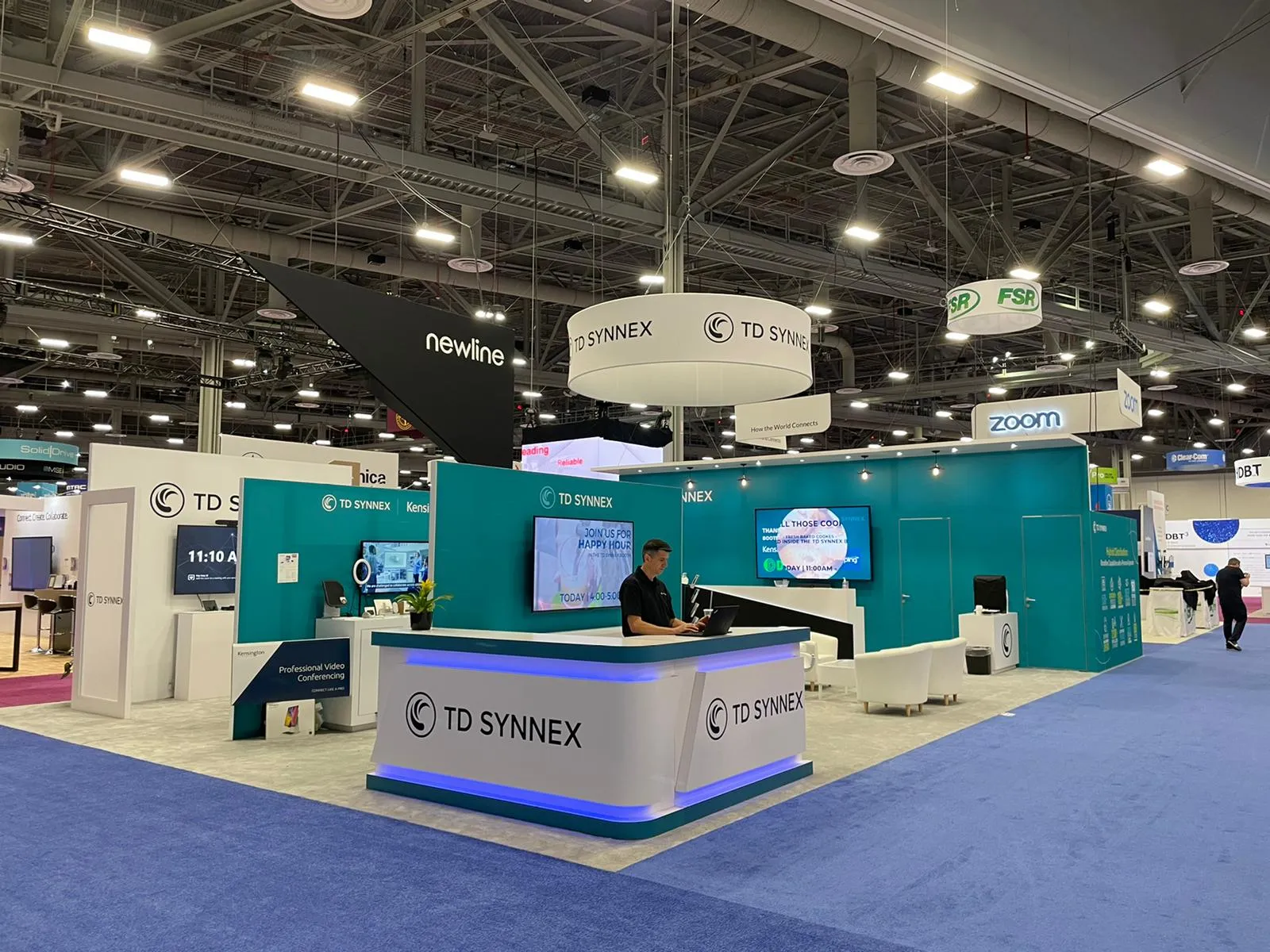 Custom trade show exhibit rental with a large LED video wall and modern furniture on the floor of a convention center in Orlando.