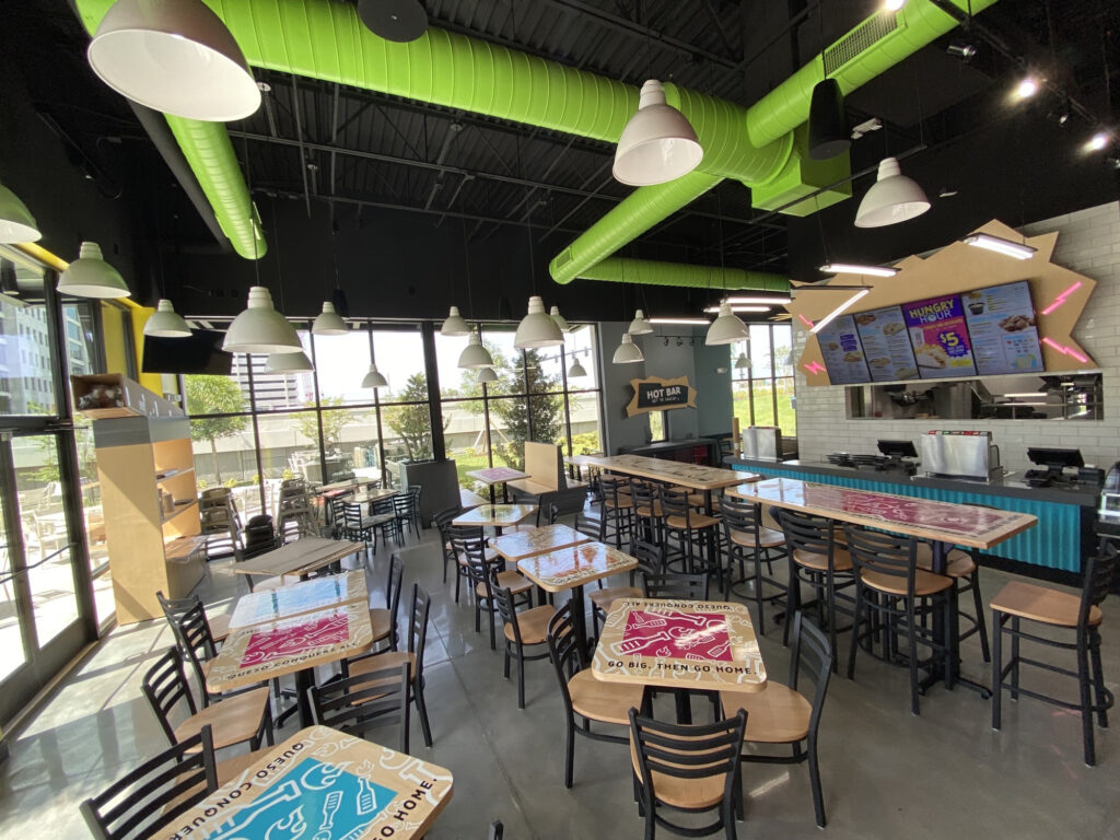 Tijuana Flats restaurant interior designed by FX Design group features large windows, natural lighting, and a view of the action on the street.